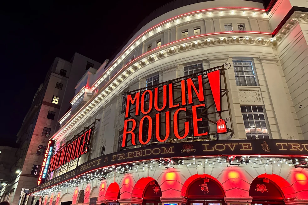 A building with red lights written Moulin Rouge