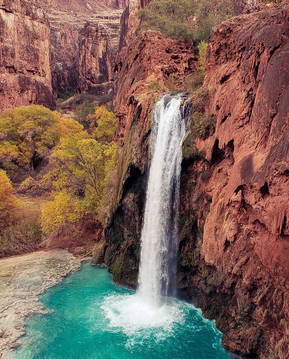 A picture of a waterfall and mountains during daytime.