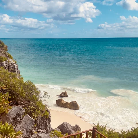 stairs leading down to the beach with ocean in the background