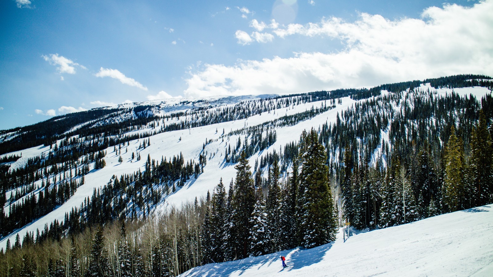 Snowy ski slopes with blue skies during daytime