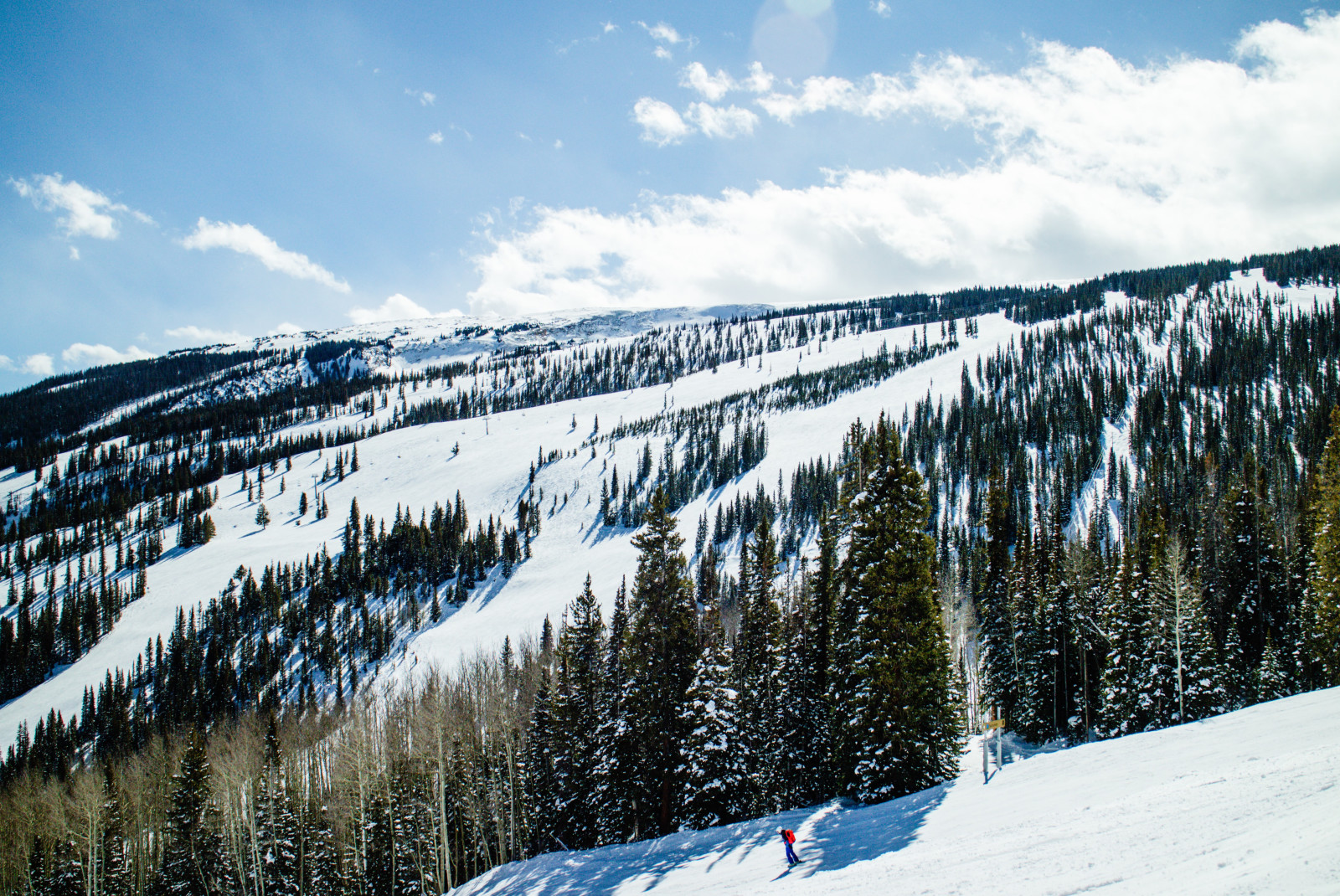 Snowy ski slopes with blue skies during daytime