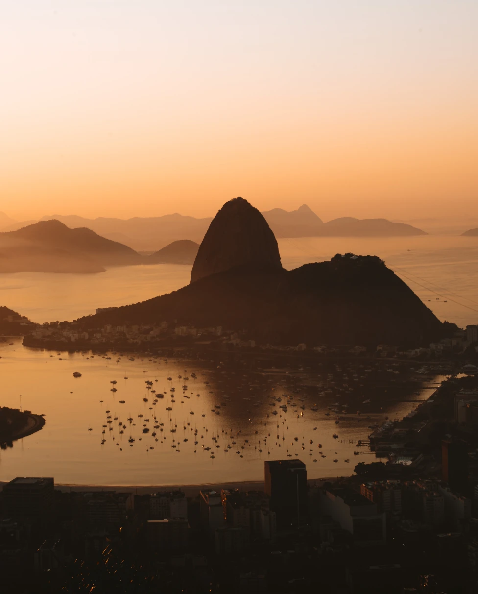 sunrise over calm waters and silhouettes of mountains 