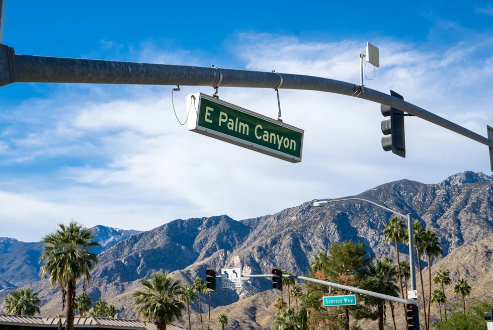 Road sign with mountains in the background during daytime