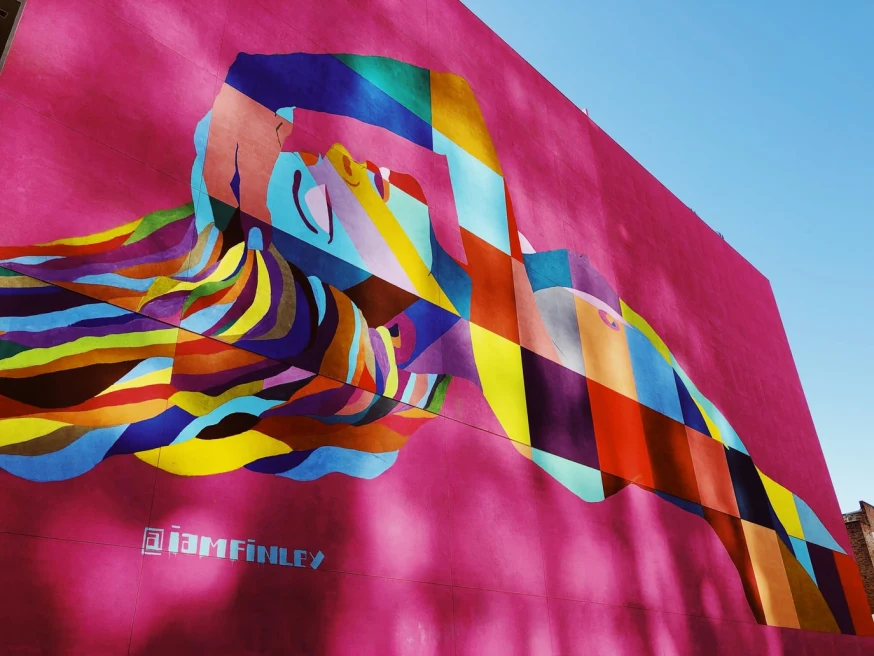 street art in los angeles on pink wall woman multi colored