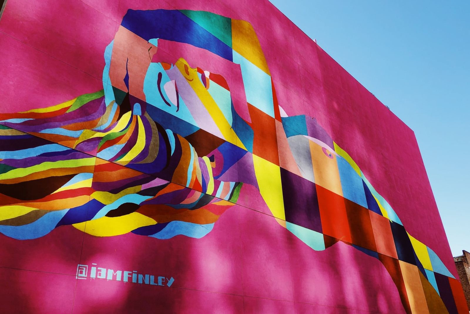 street art in los angeles on pink wall woman multi colored