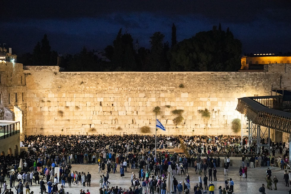 people standing in front of stone wall at nighttime