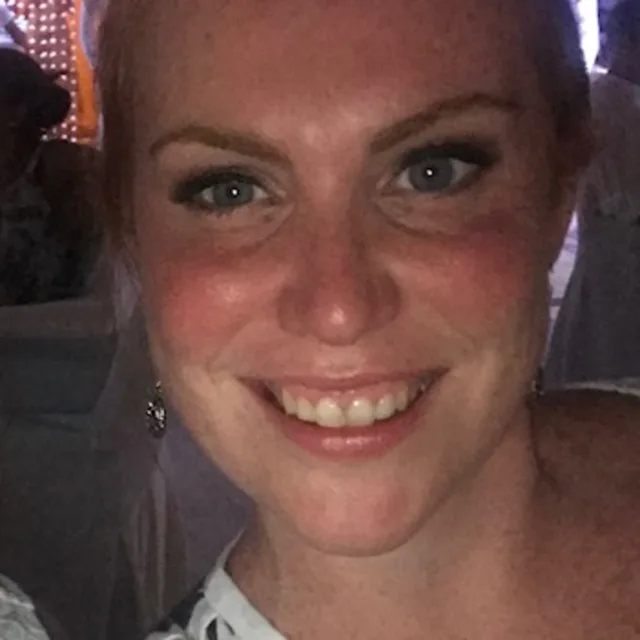 Travel advisor Danielle Bint smiles wearing a white t shirt with black design