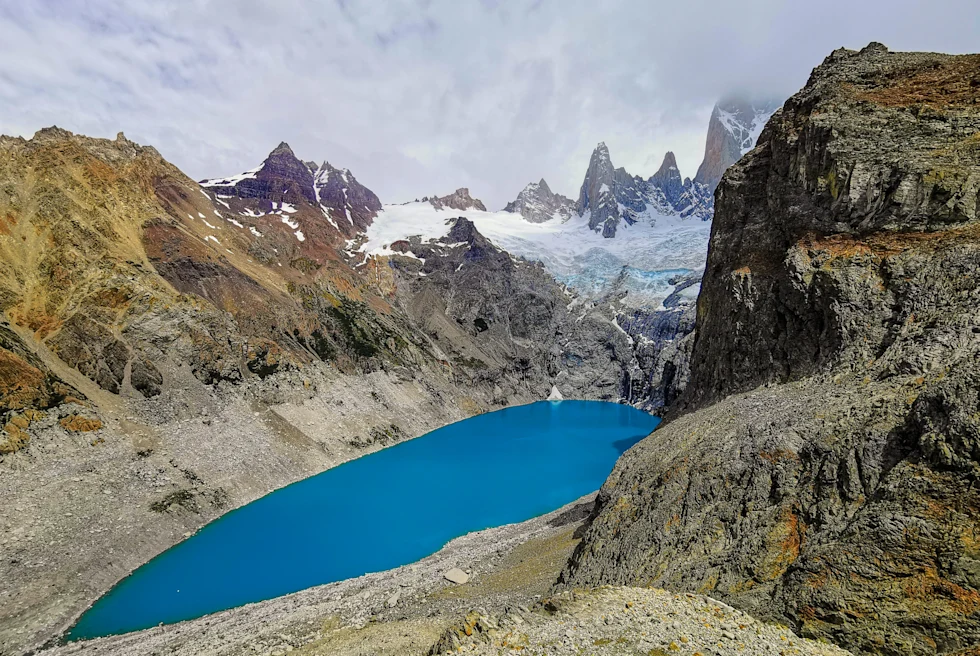 bright blue lake surrounded by snow-capped mountains