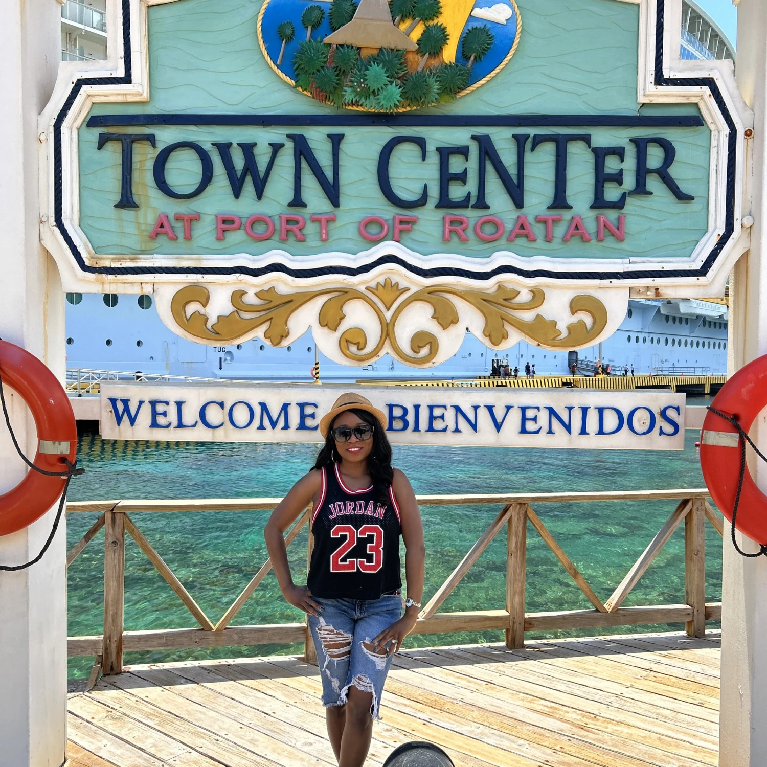 travel advisor stands in front of a large sign that reads, "town center"