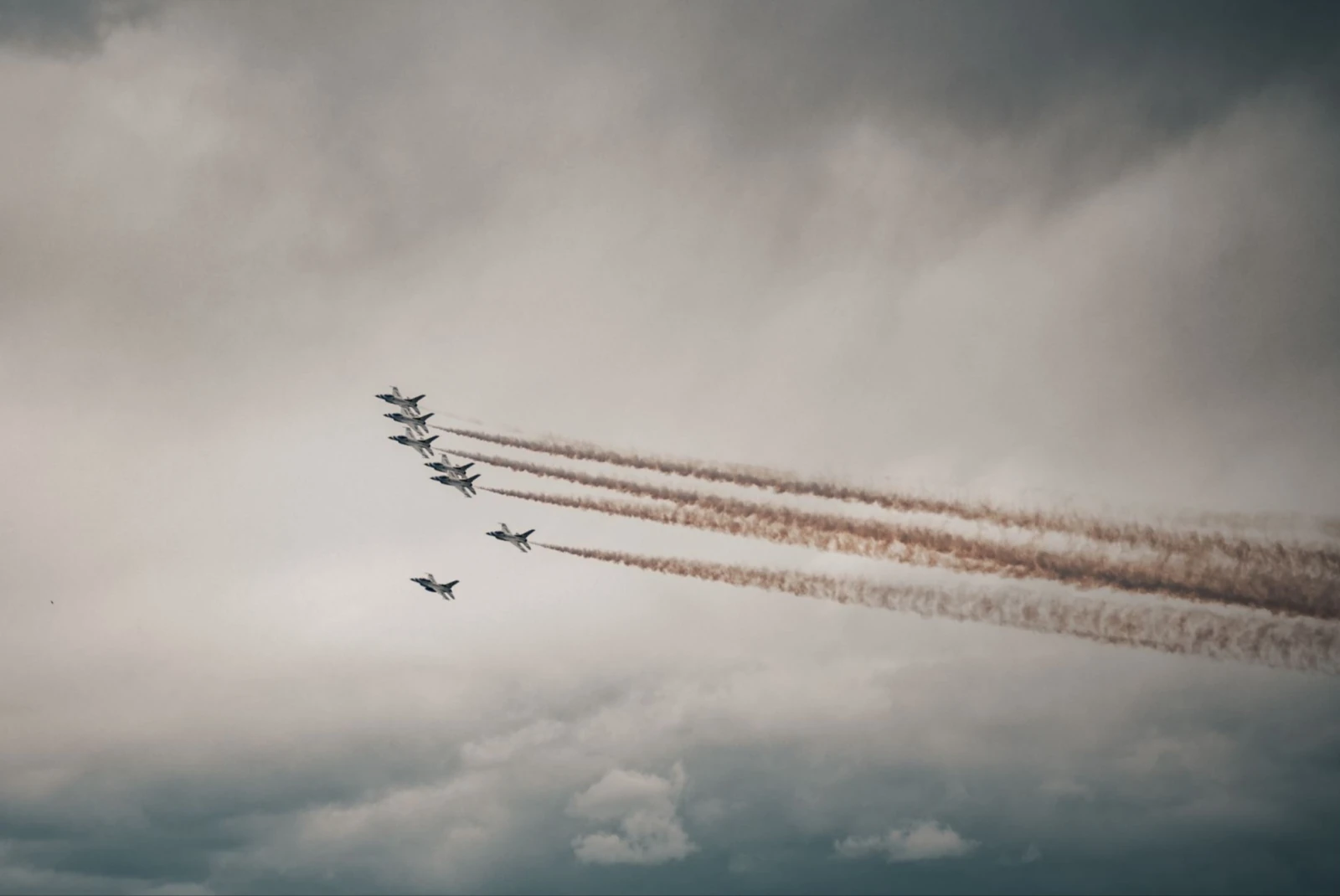 army aircraft flying in unison in a cloudy sky