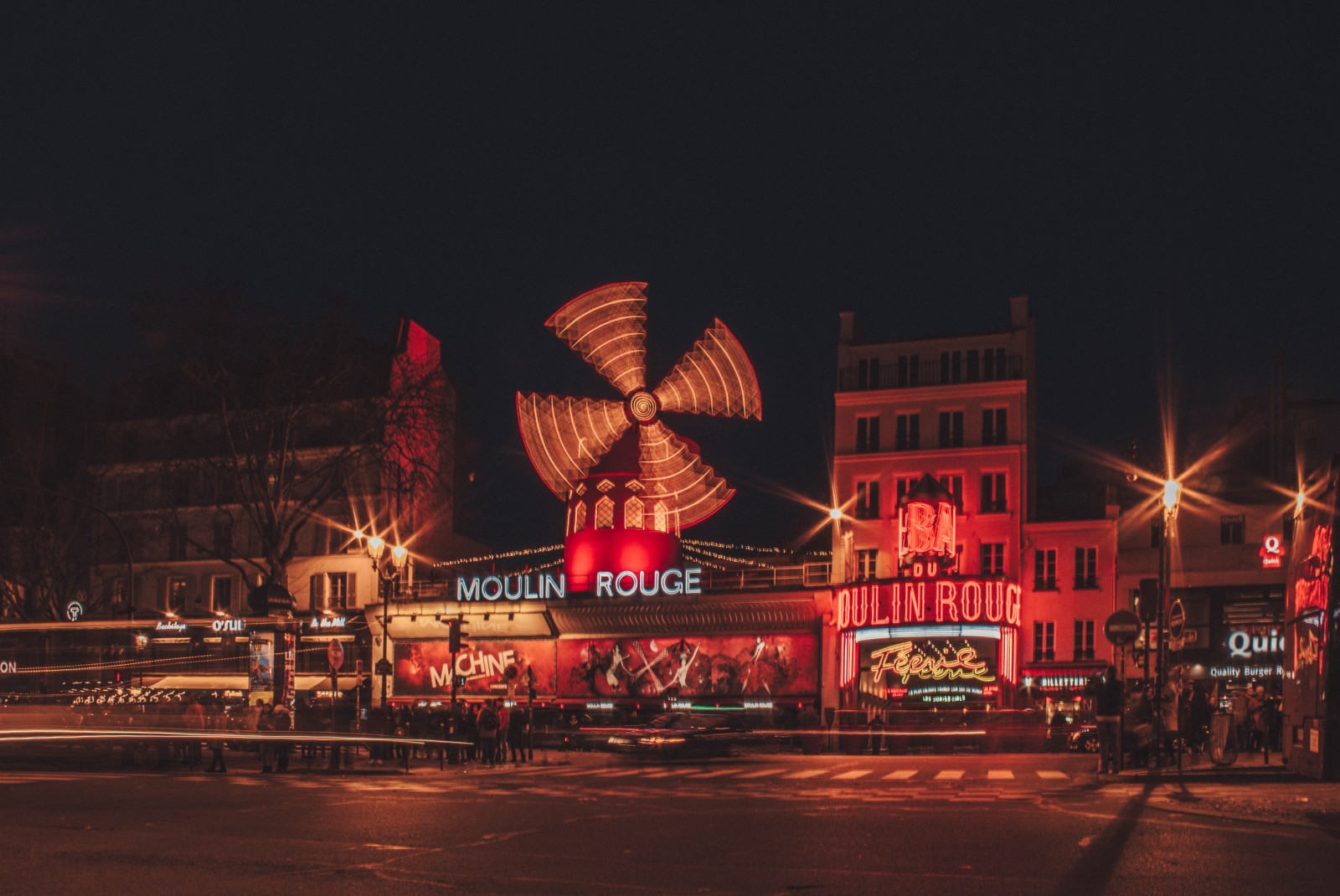 red moulin rouge night paris france spinning windmill buildings street lamps