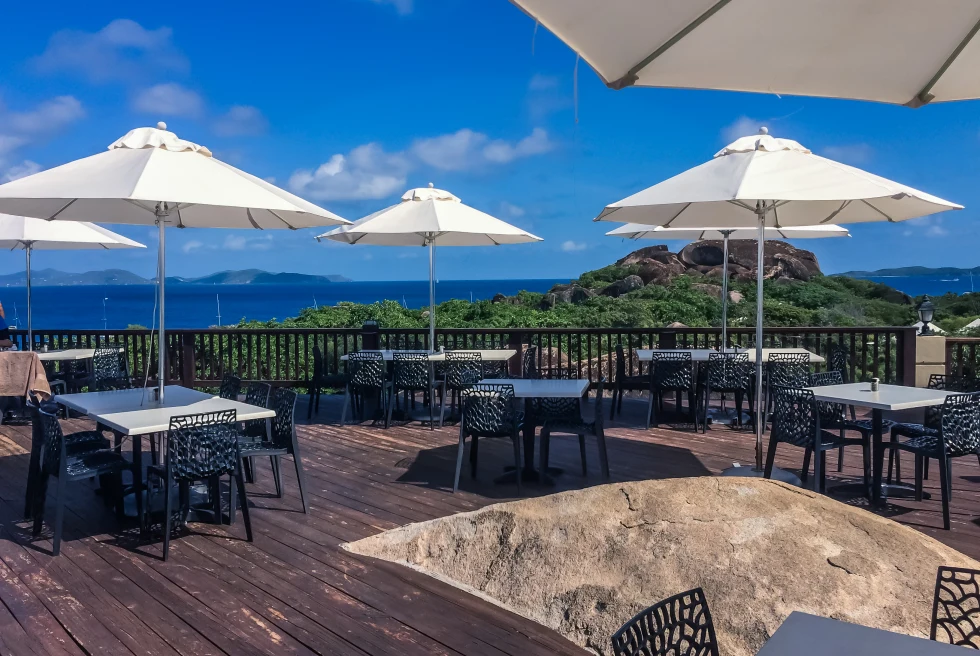 tables and chairs overlooking the water during daytime