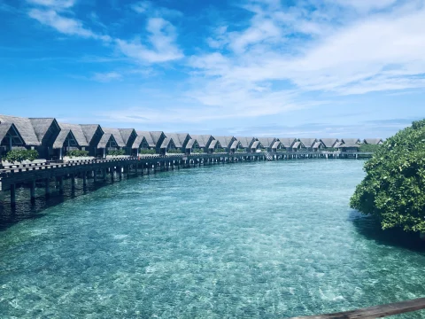 a row of bungalows over turquoise water