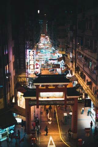long city street with night market lit up by 