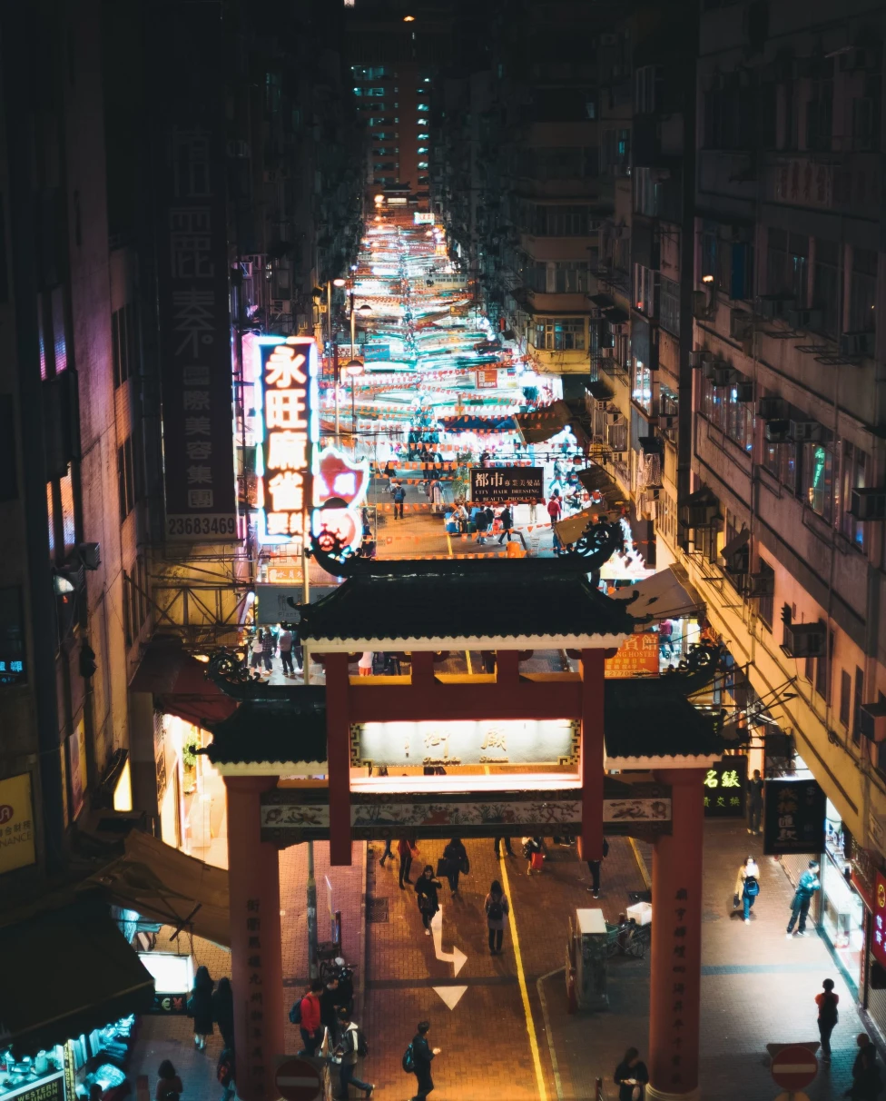 long city street with night market lit up by 