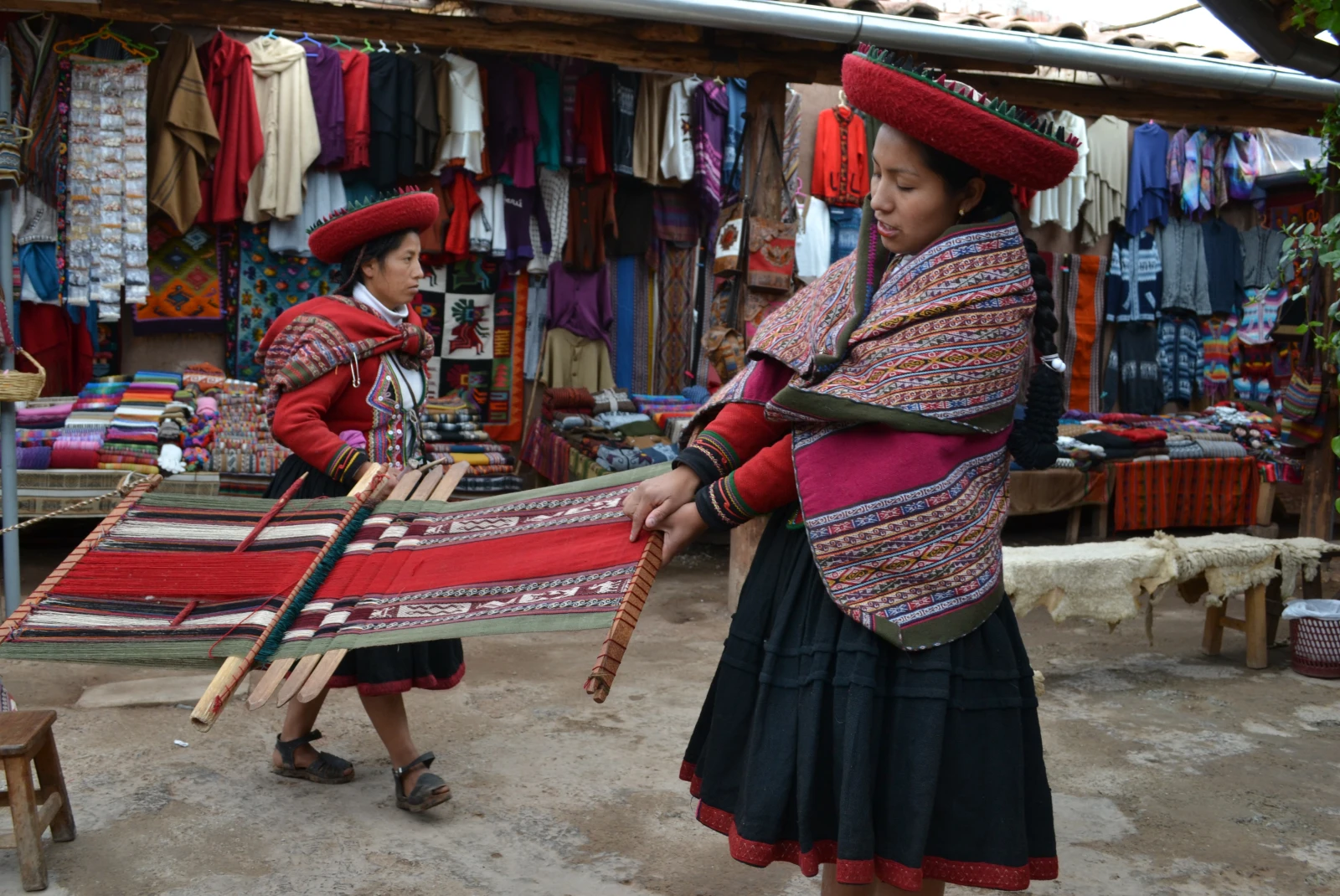 A local artisan in the Sacred Valley of Peru weaving red, black and white wool.