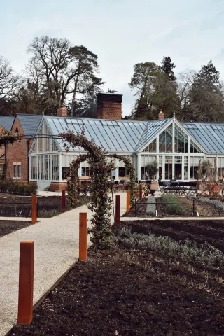 A garden and path leading to a house with glass windows and doors