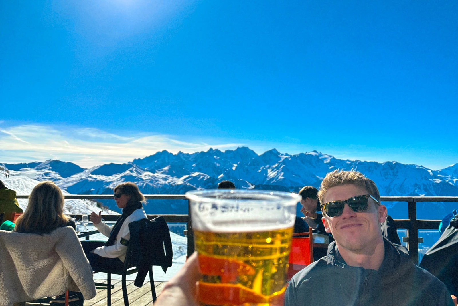 woman cheers beer to man on snow mountain cafe