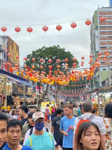 A busy street filled with people and red lanterns in Kuala Lumpur.