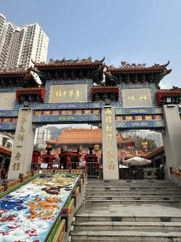 A colorful building with ornate entrance gates and Mandarin writing on them. 