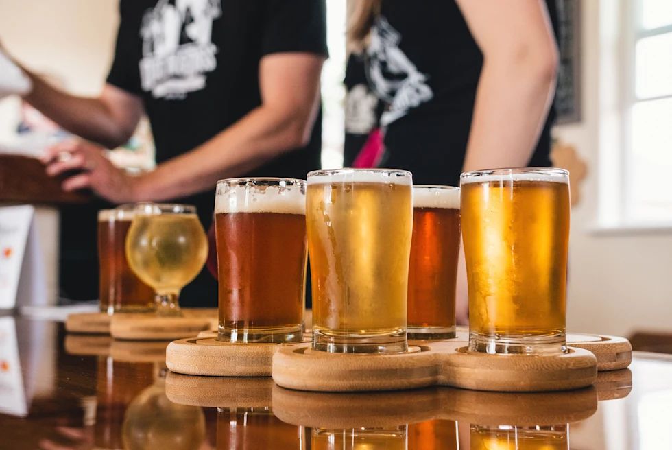 A wooden plate with various beers.