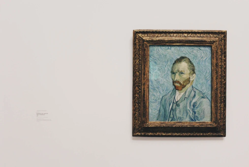 Van Gogh self-portrait against white wall in museum.