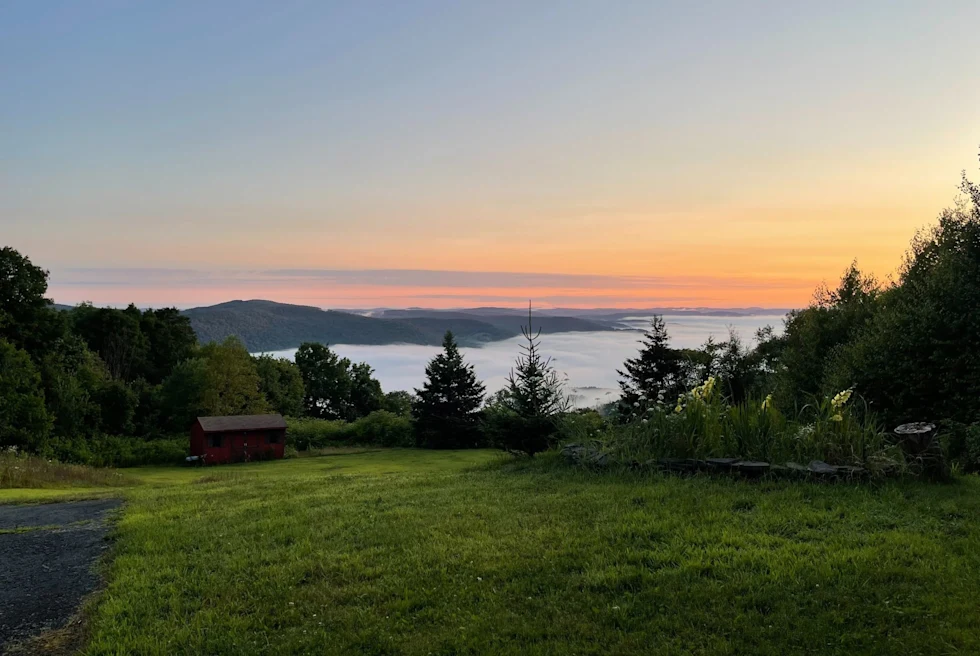 a sunset over a lake and hills