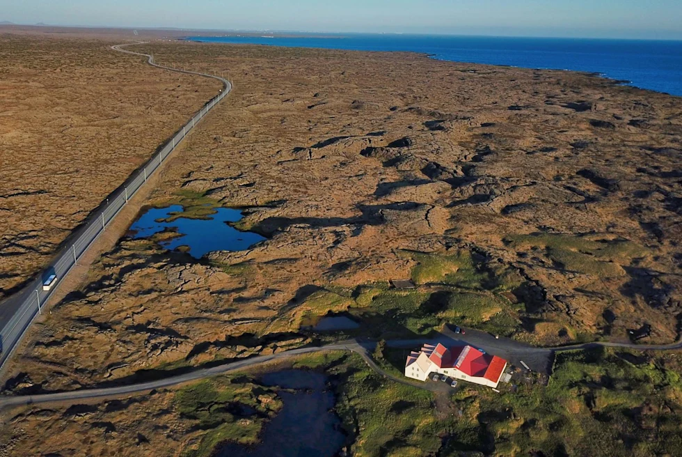 a peninsula with a long road through it and a white house in the foreground