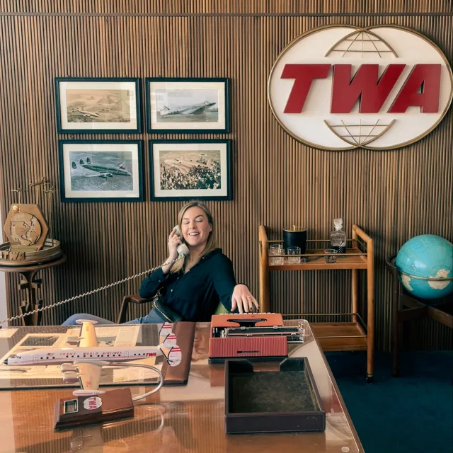 Travel Advisor Samantha Porter talking on a landline in TWA office. 