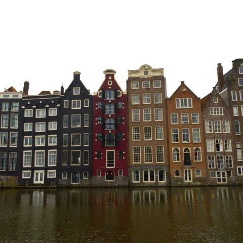 A rowe of tall buildings on a canal 