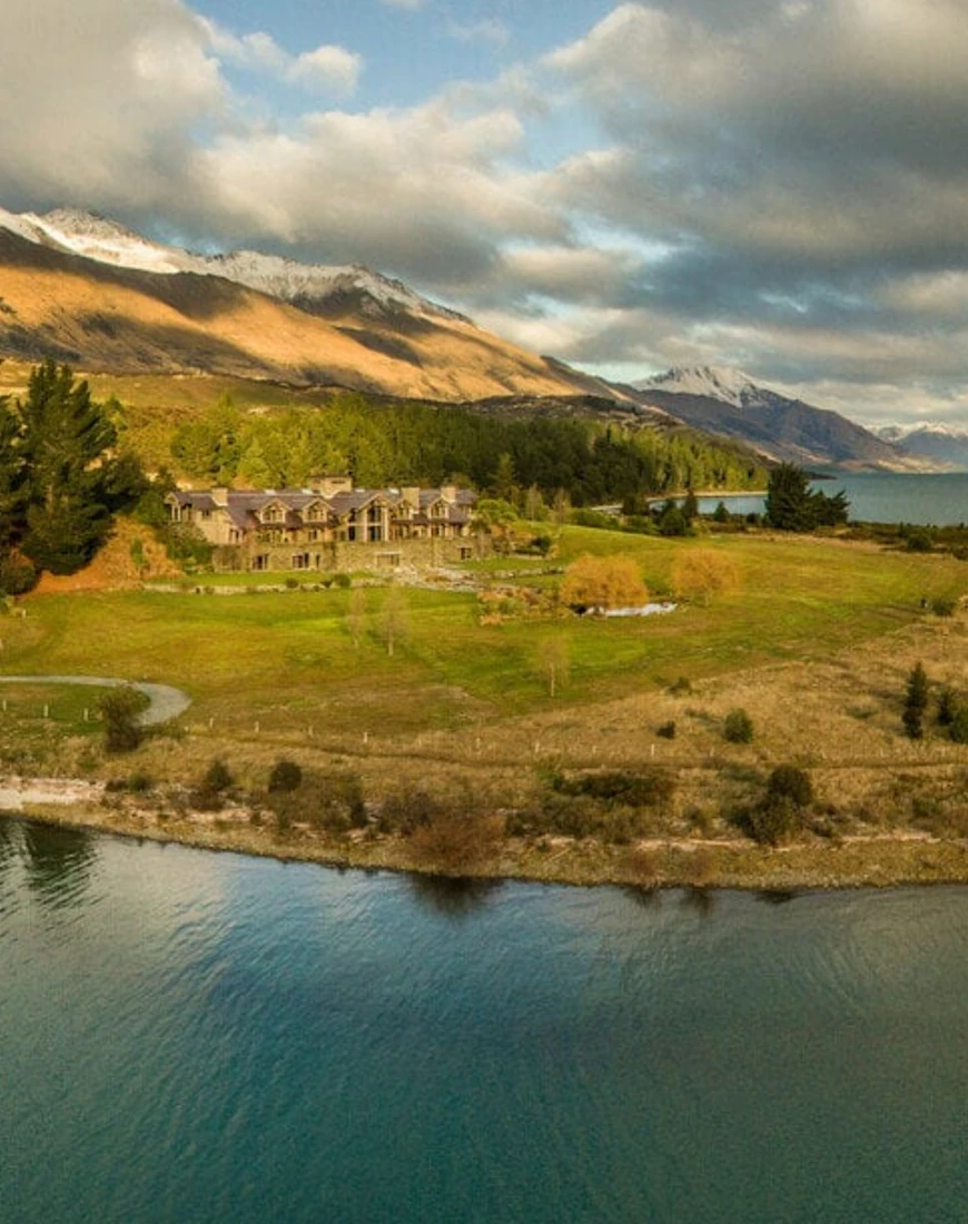 a rustic alpine lodge on a gassy expanse overlooking a lake