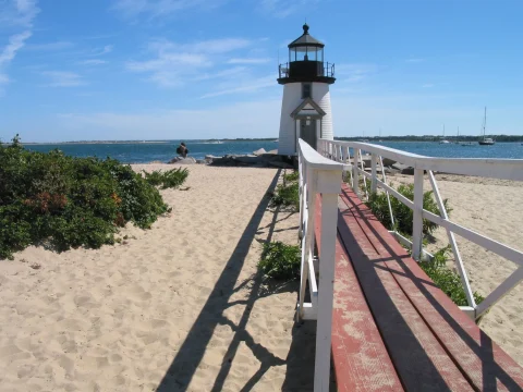 A lighthouse near a beach during daytime.