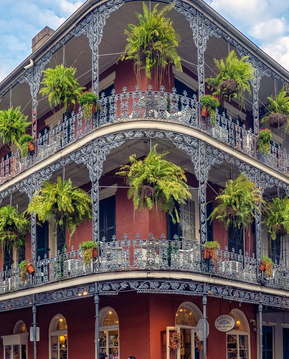 A huge building having trees hanging on the balcony