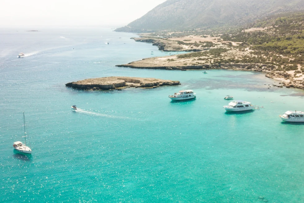 Light blue sea with boats sailing on it. 