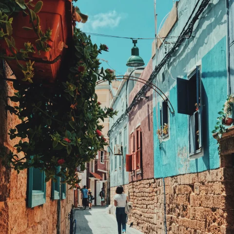 Girl walking down colorful street on a sunny day during daytime