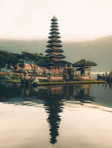 A picture of a temple beside a body of water during daytime.