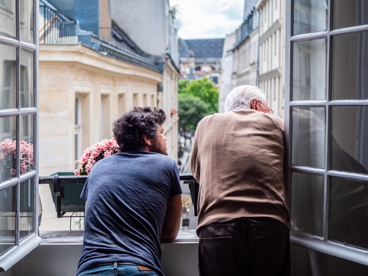 Two men looking out of the window in Le Marais. 