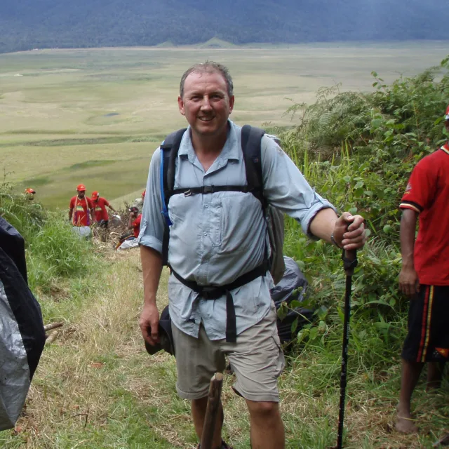 man wearing hiking clothes standing outside