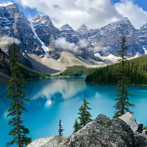 A blue lake surrounded by mountains and trees.