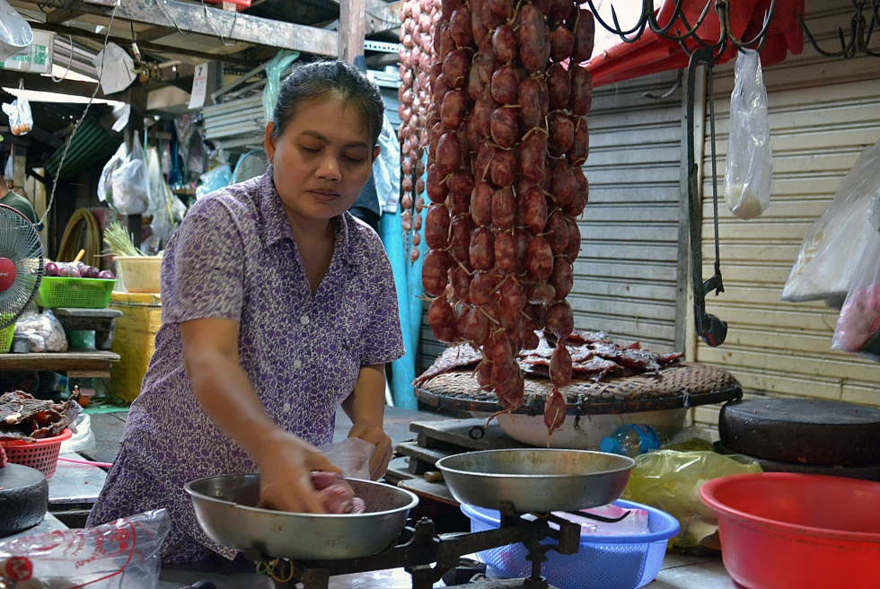 A woman making food in a street stand. 