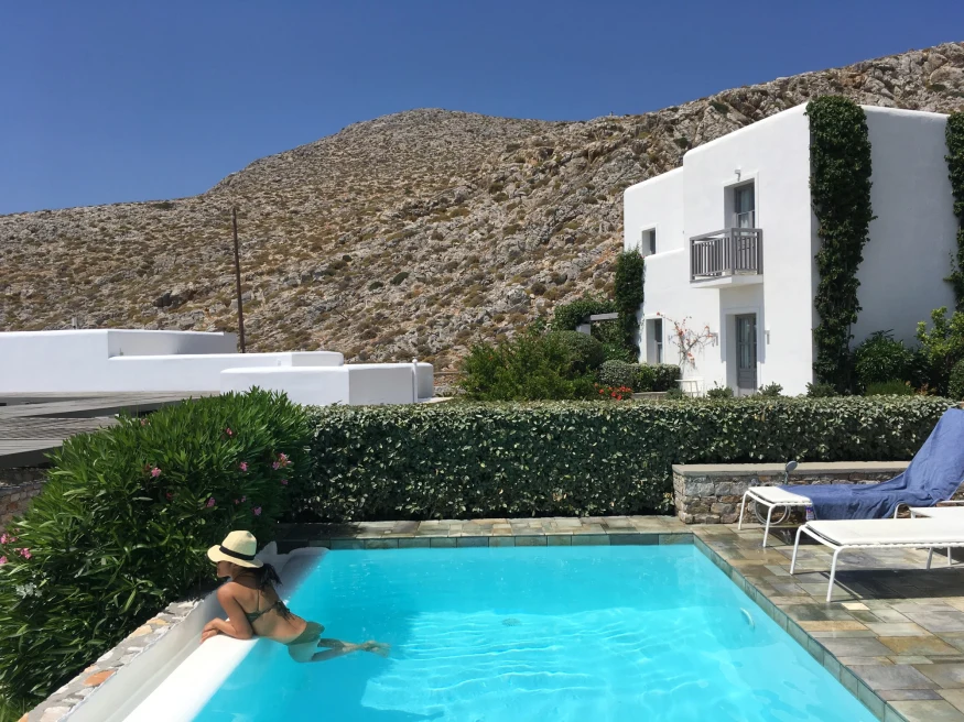 travel advisor lounges in small pool outside a white buildings