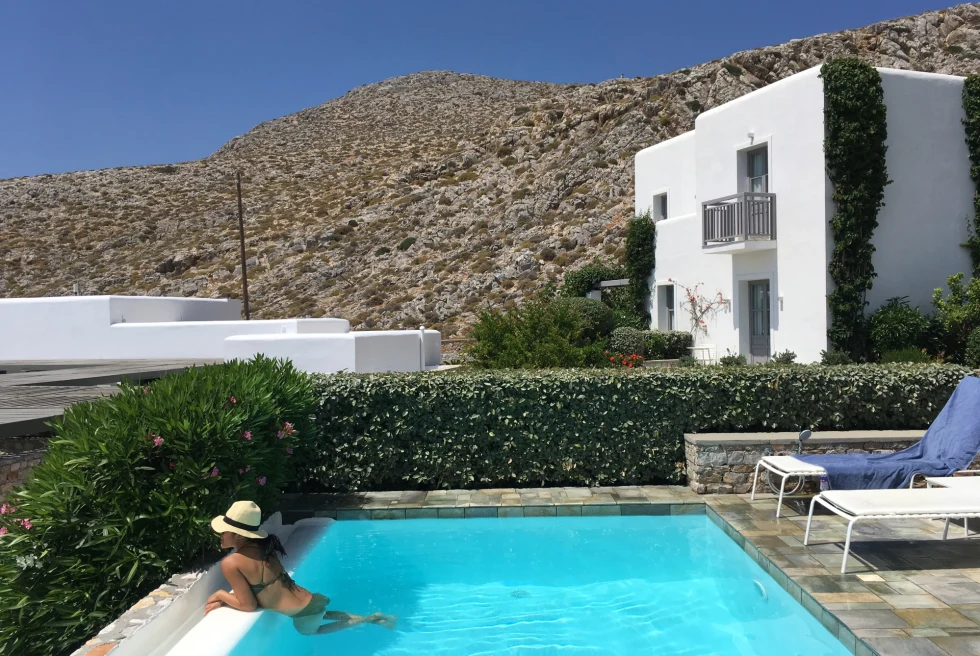 travel advisor lounges in small pool outside a white buildings