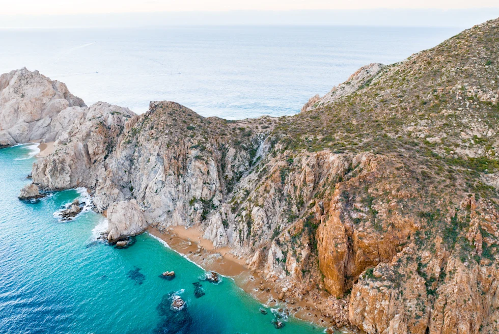 aerial view of mountainous coast next to body of water