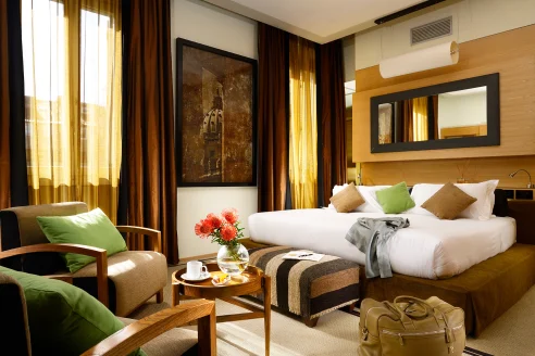 chic Italian hotel room with green pillows