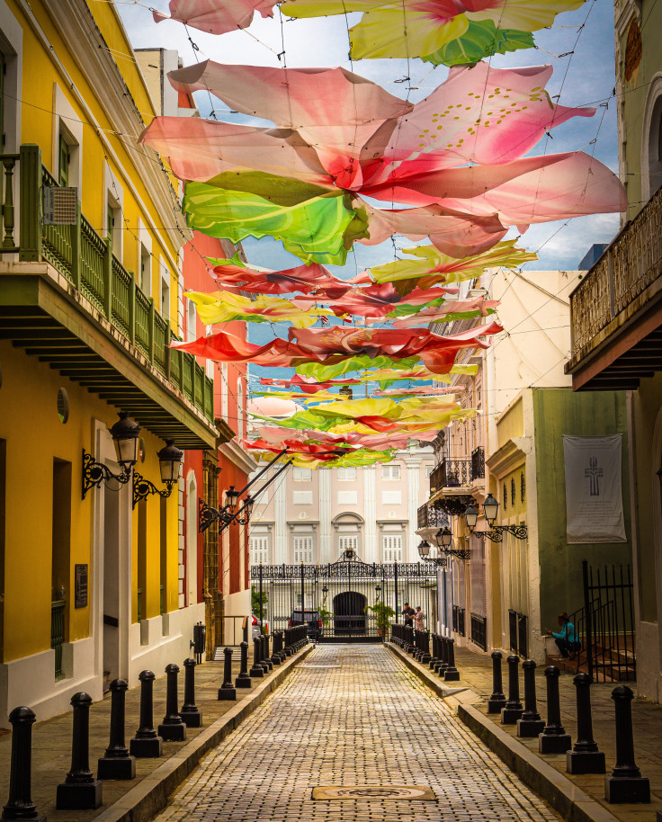 Street with colorful umbrellas hanging overhead during daytime