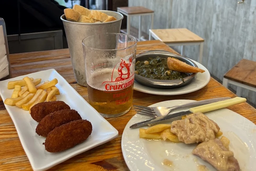 Multiple food items and a drink on a brown table inside a restaurant.