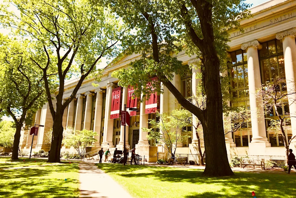 white academic building with columns and red flags