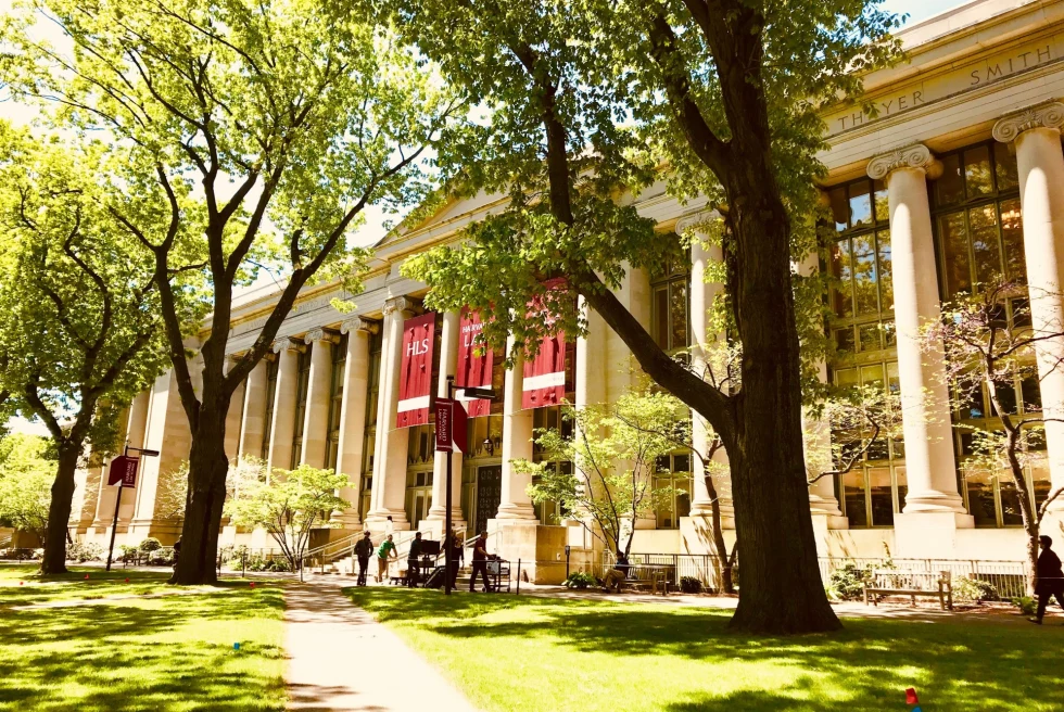 white academic building with columns and red flags