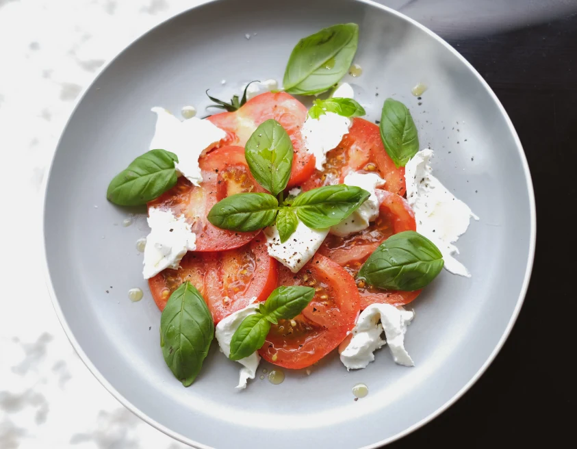 Caprese salad with mozzarella cheese, tomatoes and basil.