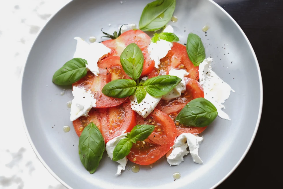 Caprese salad with mozzarella cheese, tomatoes and basil.